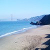 sandy beach and ocean with Golden Gate Bridge in background