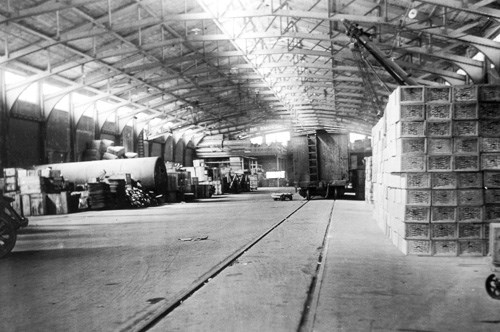 large warehouse facility filled with crates and a freight car