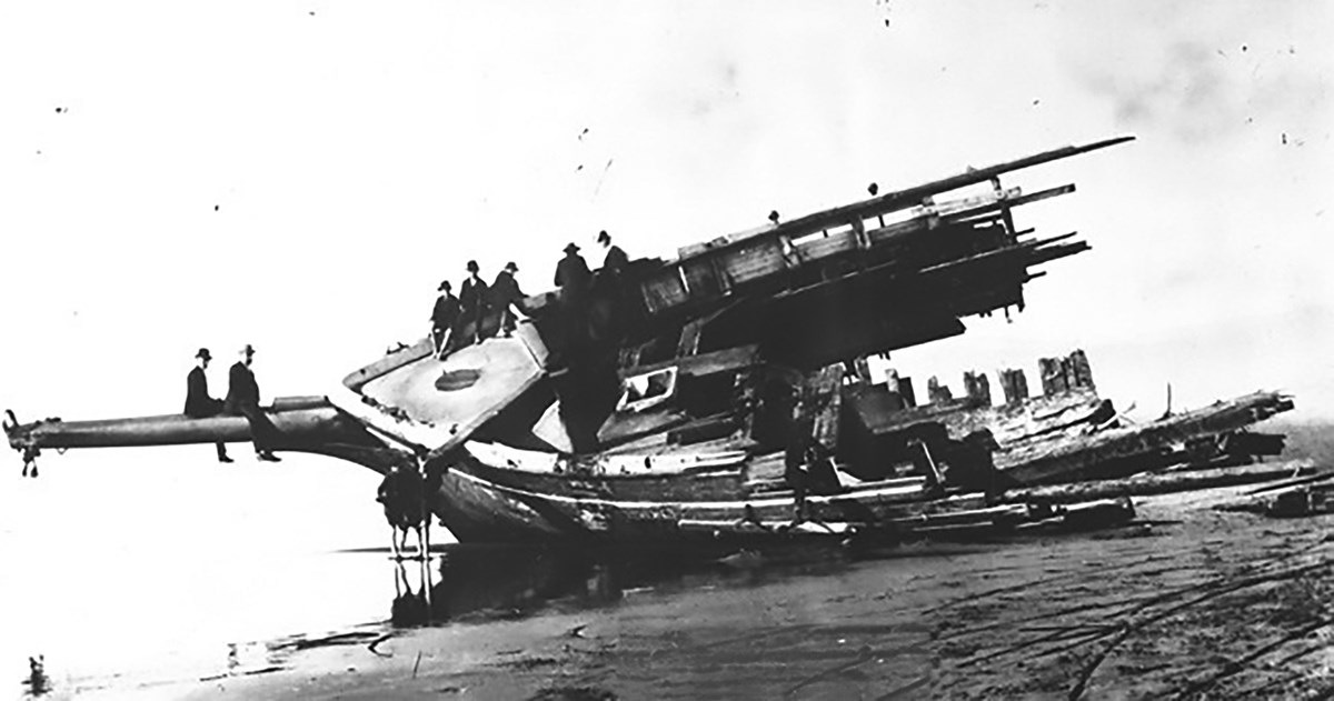 men assembled on remnants of a shipwreck.