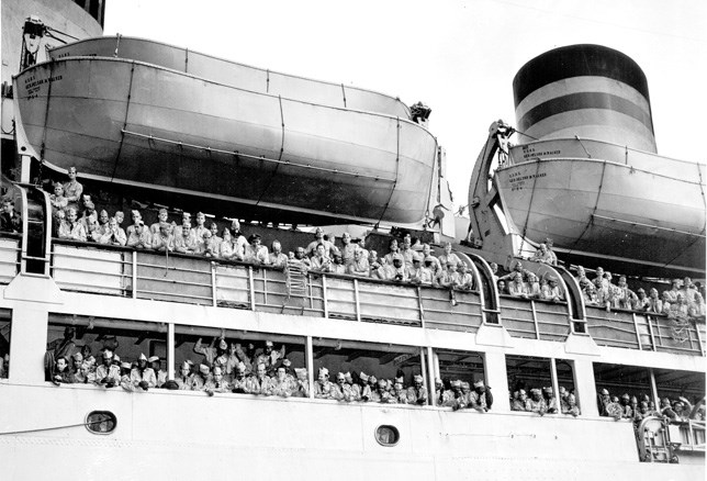 soldiers leaning over ship railing