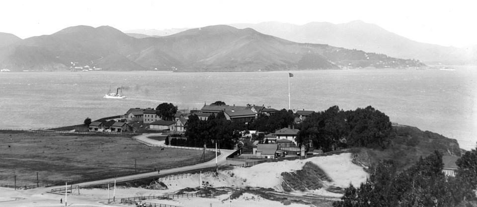 cluster of historic buildings on bluff with water behind