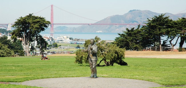 large statue of a man in a open meadow