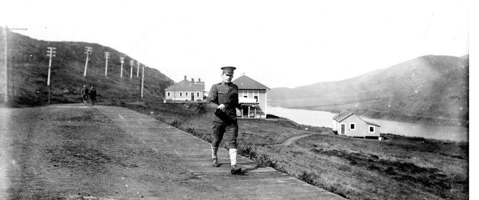 man in uniform walking on rural road