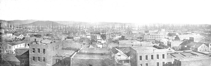 A view across rooftops towards Angel Island, with ships masts along the waterfront from 1853.