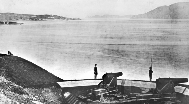 soldiers at attention overlooking bay of water