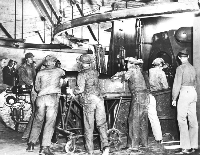 Soldiers at Battery Townsley Black and white photo depicts soldiers loading large equipment to prepare Battery Townsley's gun for firing.