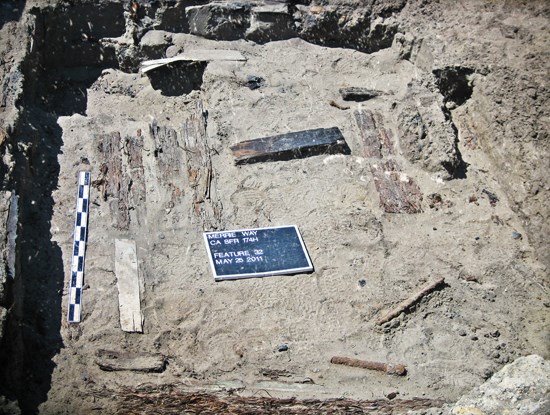 open excavation site with wooden features stuck in the dirt
