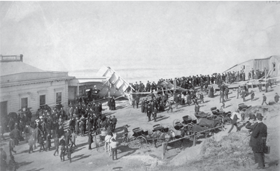 A group of people gathered to view the aftermath of a ship explosion.