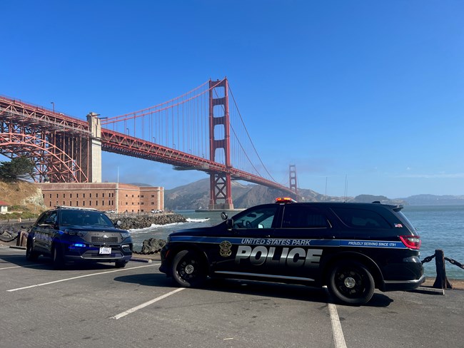 United States Park Police vehicles in front of Fort Point and the Golden Gate Bridge.