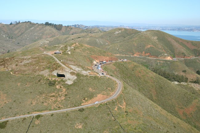 An overhead view of Hawk Hill, with the parking lot next to a trail leading up to the top where one can see the old Nike radar buildings.