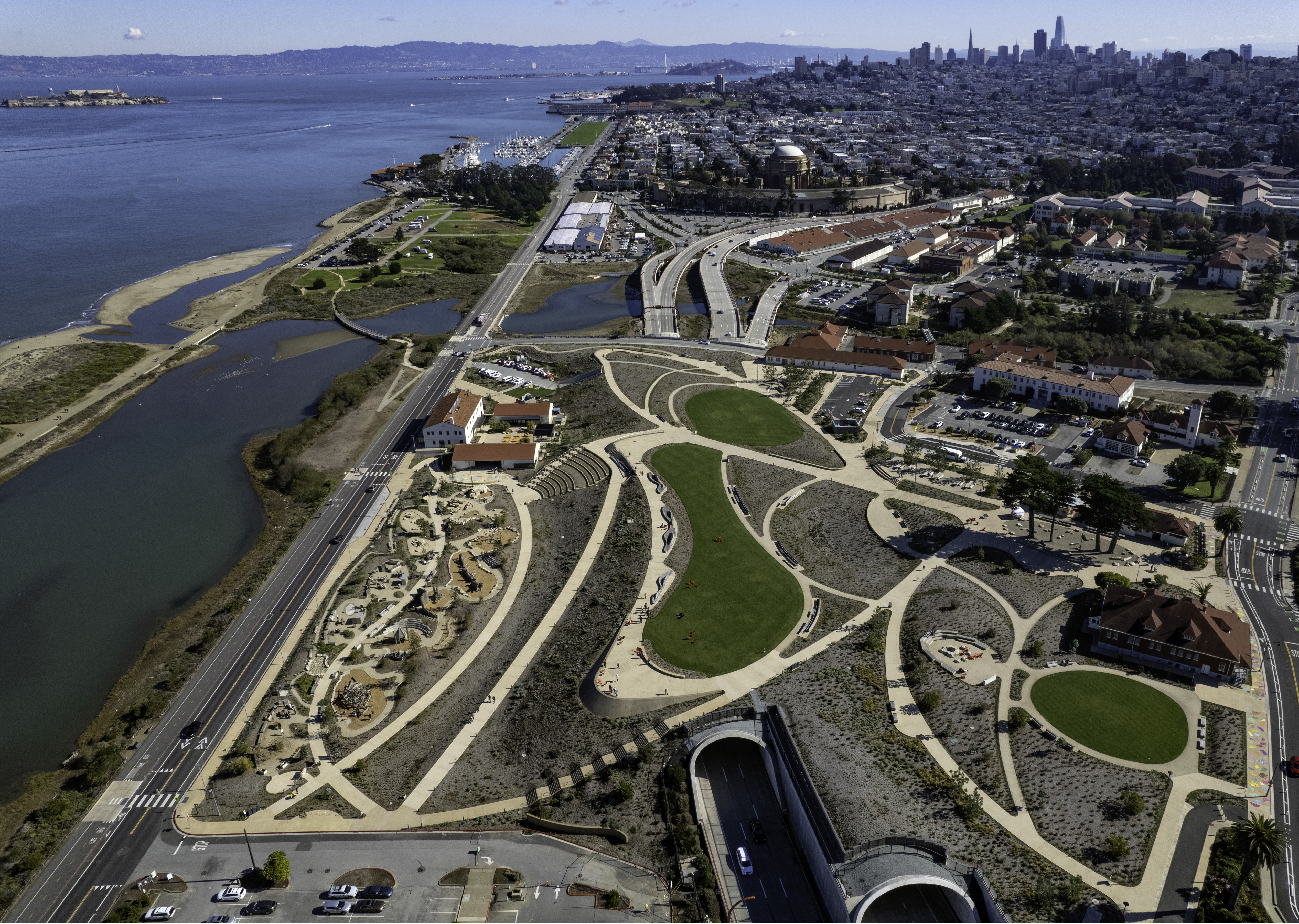 Color aerial view of San Francisco Bay, Presidio Tunnel Tops, Crissy Field, and Alcatraz Island.