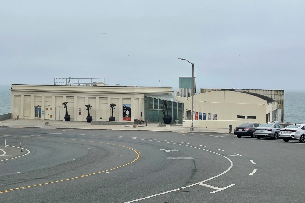 Lands End Restaurant Properties A beige art deco building with a parking lot in front of it