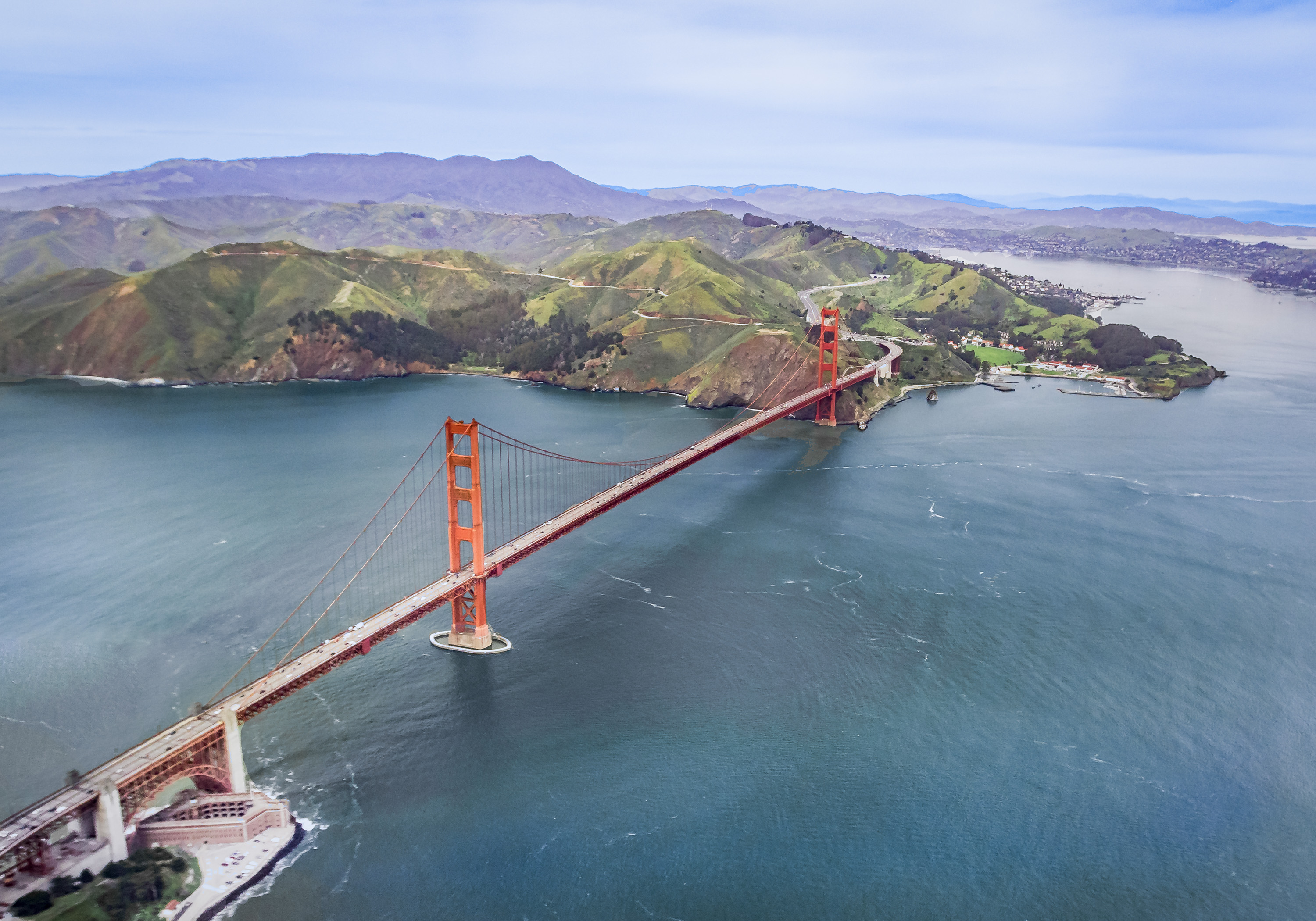 An aerial view of the Golden Gate Bridge with the San Francisco Bay surrounding it