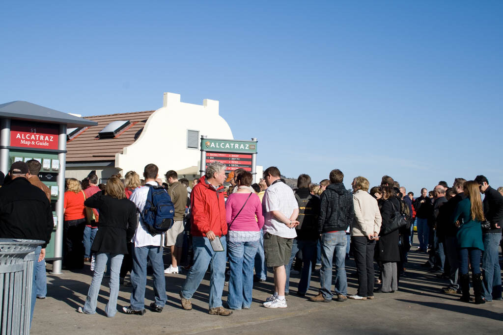 A group of people gathered around the dock on Alcatraz A group of people gathered around the dock on Alcatraz