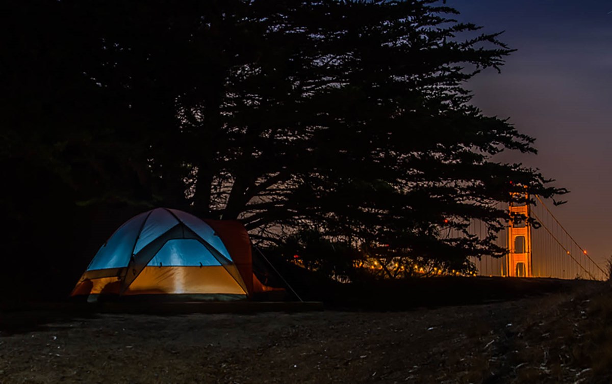 tent on hill overlooking the bridge at night
