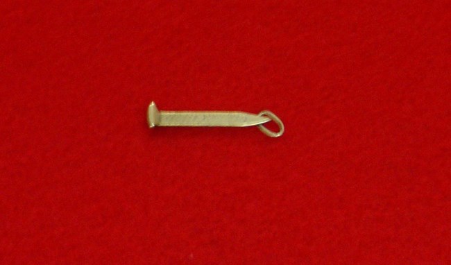 A miniature golden spike fashioned into a watch fob.