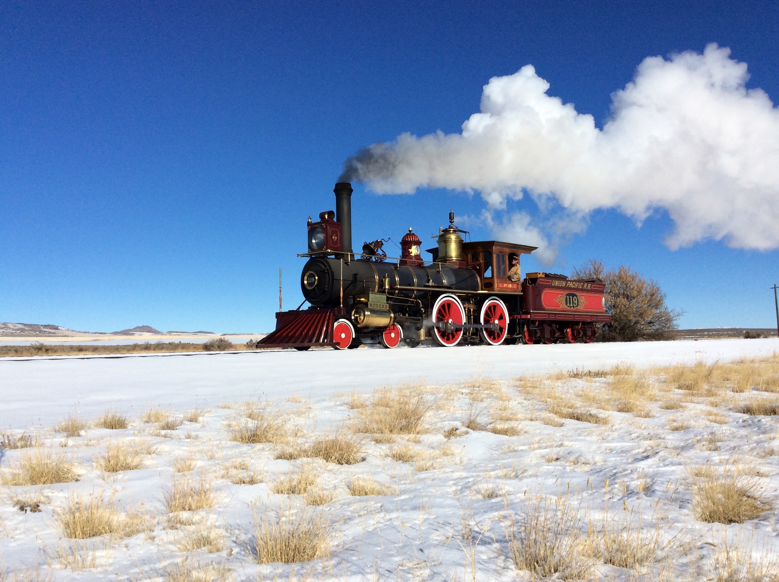 No.119 a Red and Black 1869 steam locomotive replica on tracks surrounded by snow