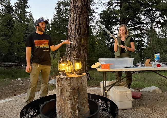 two researchers around lanterns with a rattlesnake in a tube