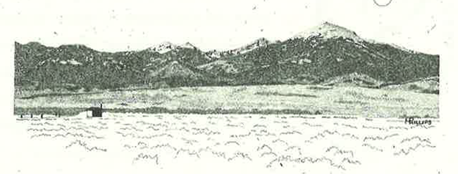 A snow-covered mountain range with a low valley in the foreground.]