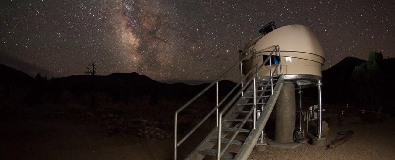 An open telescope observatory with milky way in the background
