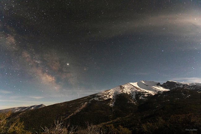 Doso Doyabi faintly lit by moonlight with the milky way arching through the sky to the left