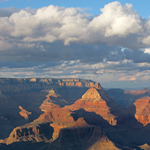 A blanket of clouds floating over a fiery Grand Canyon during sunset.
