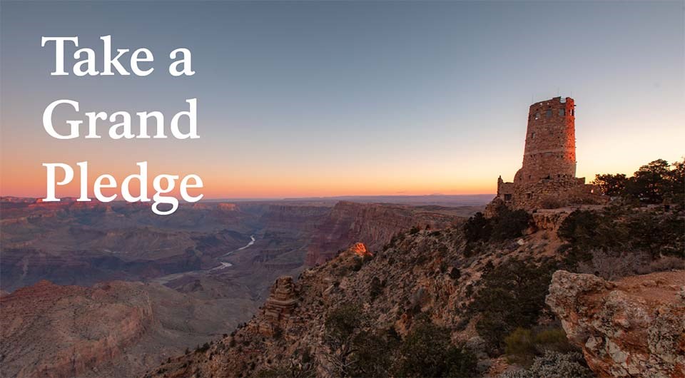 sunrise light on circular stone tower on edge of a vast canyon.