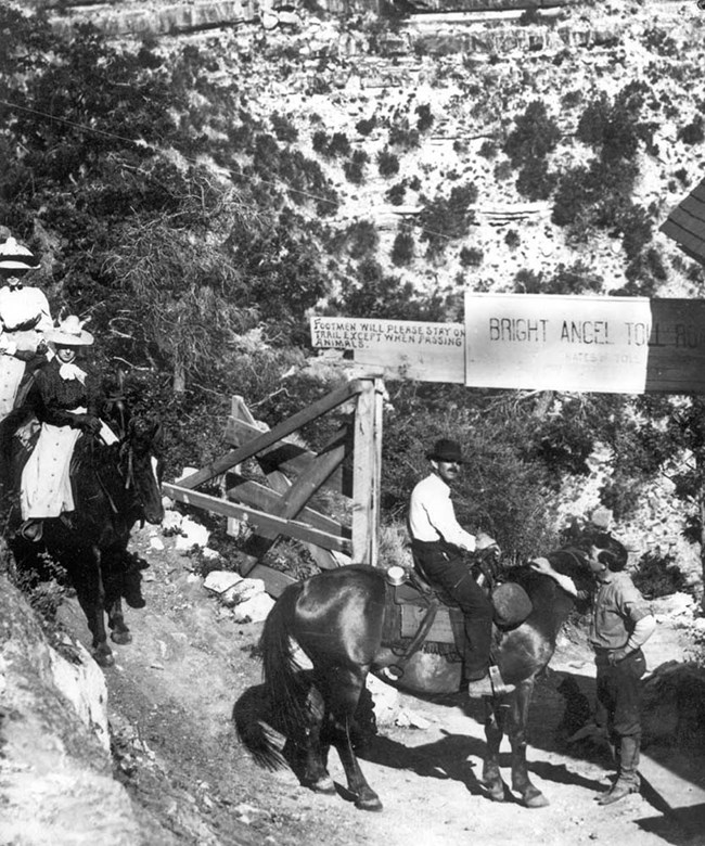 a fee collector and rider at the gate for Bright Angel Toll Road