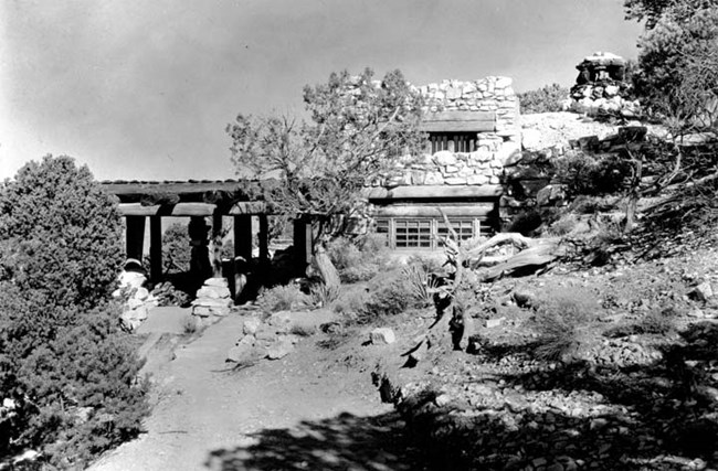 A black and white photo of a building built into the earth.