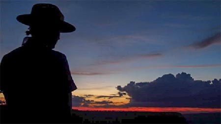 Behind a silhouetted Ranger is a twilight sky after sunset