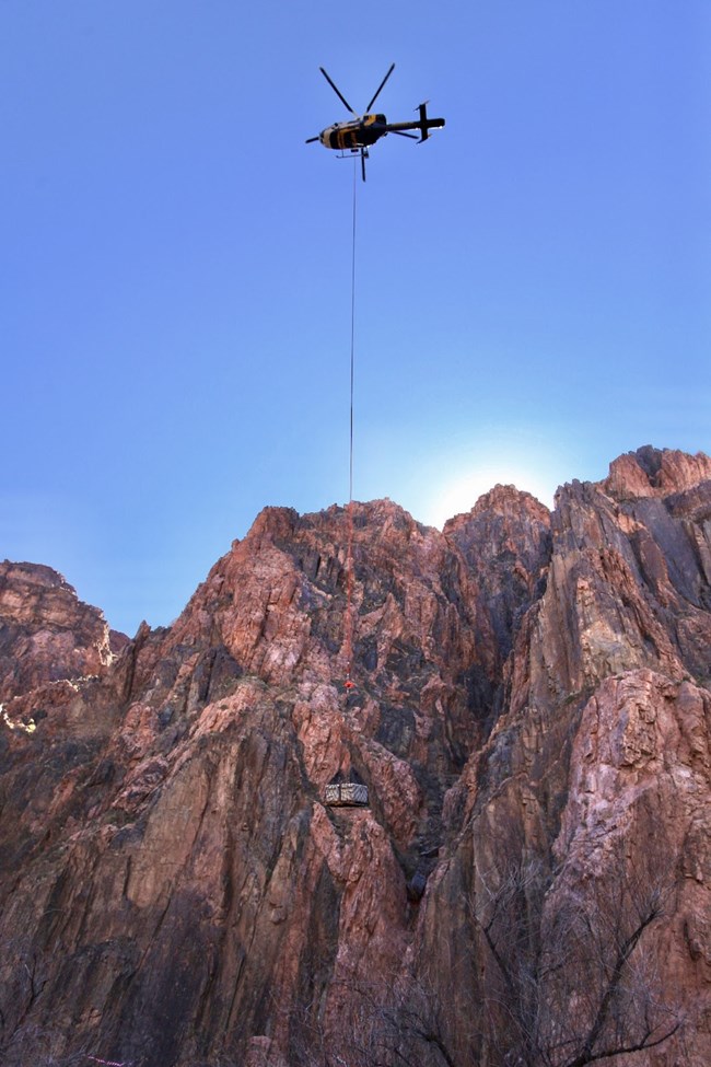 NPS helicopter with a sling-load of fish.