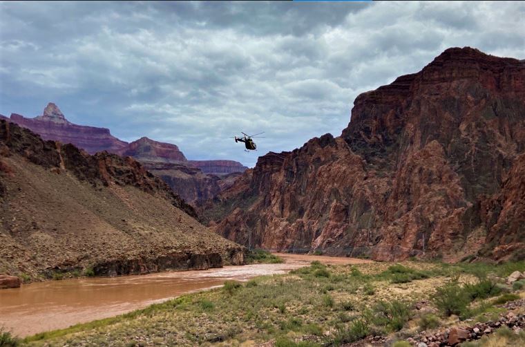 A helicopter flies near the Colorado River near Phantom Ranch