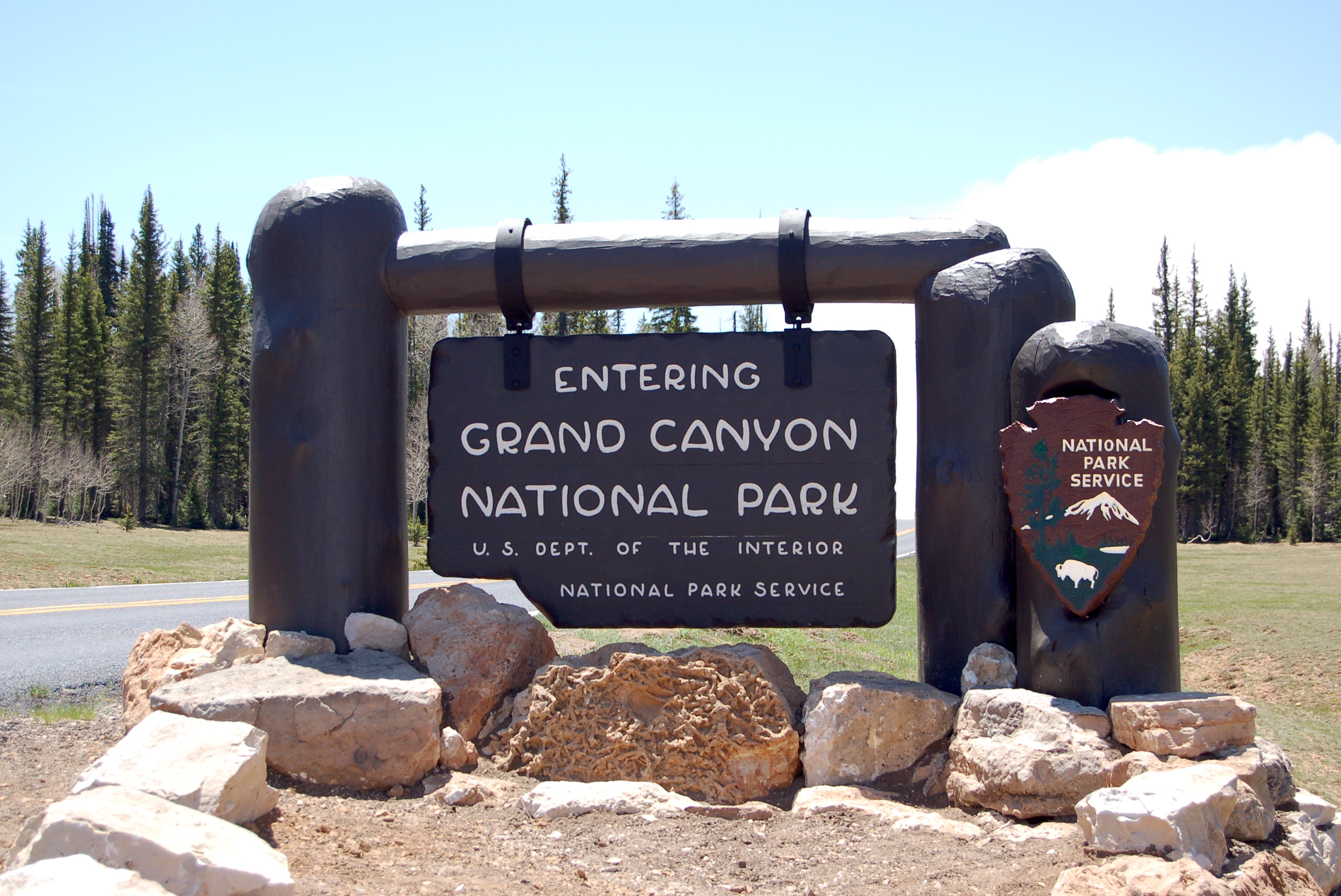 dark brown wooden Grand Canyon National Park entrance sign in a meadow