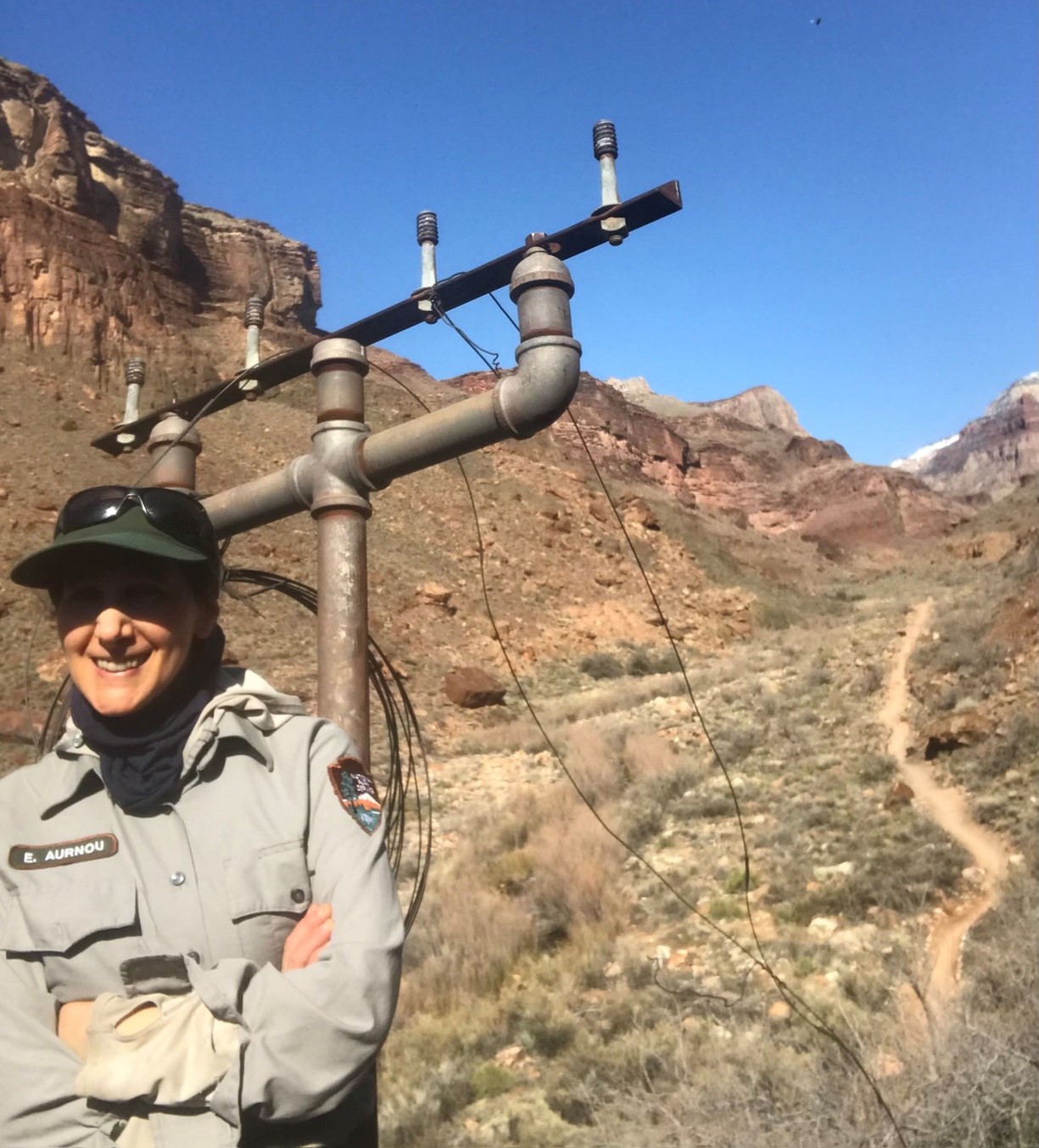 Betsy Aurnou stands next to a historic telephone pole and wires in the inner canyon