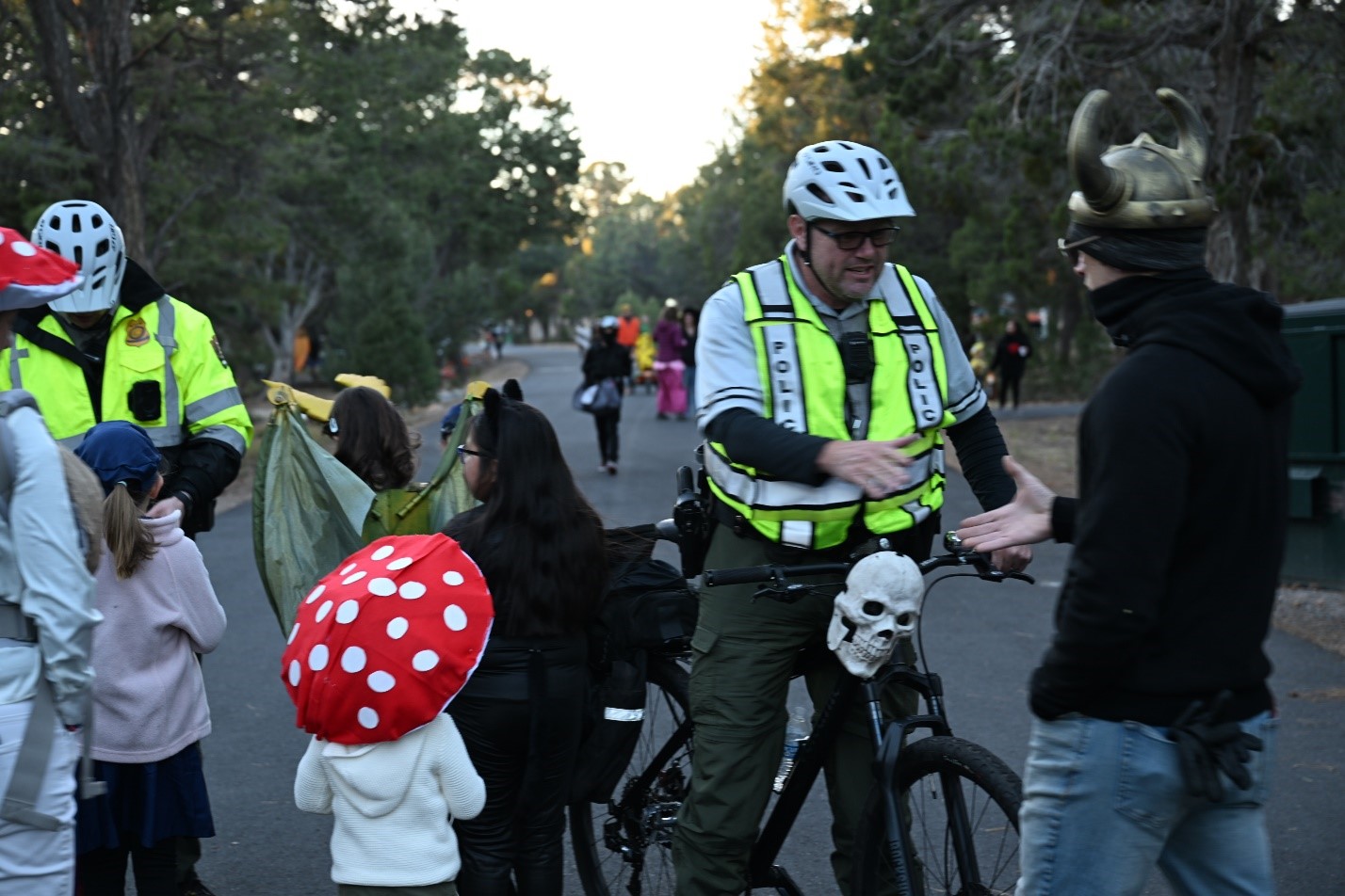 South Rim Patrol on Bike Patrol-Halloween 2024 Two rangers in reflective vests interacts with trick-or-treaters on a city street during Halloween