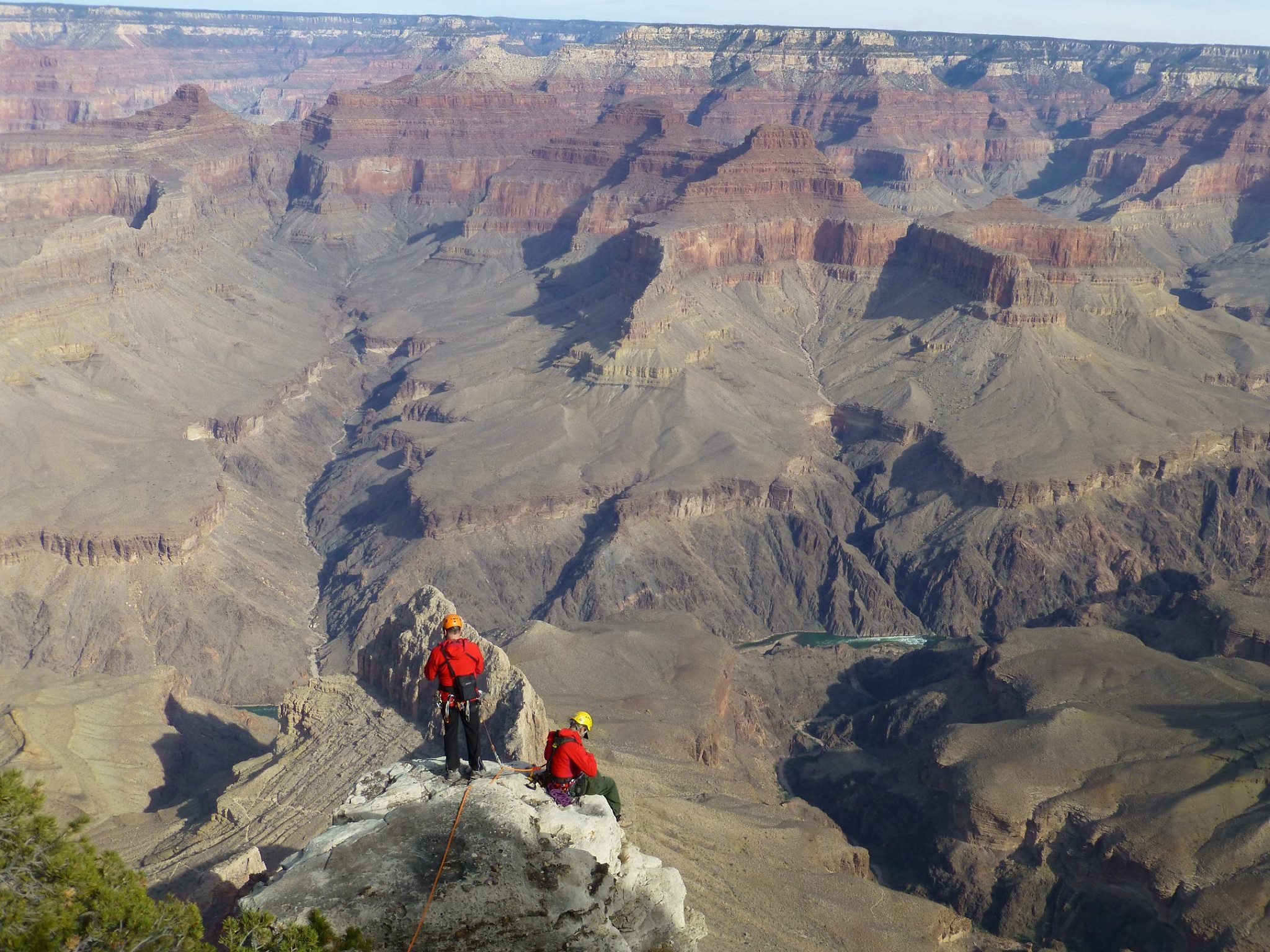Two rangers scope on a ledge on the rim of Grand Canyon
