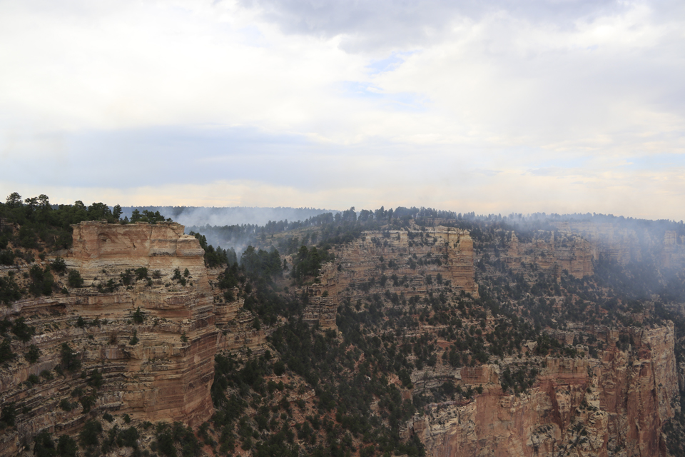 Obi Fire - Aug15 White smoke billows in from the left over the red-stained cliffs of a canyon