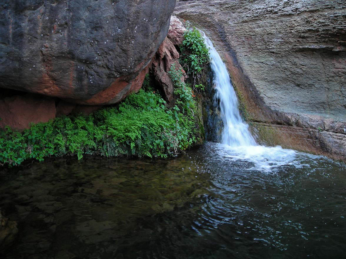 A waterfall rushes between two rock faces.