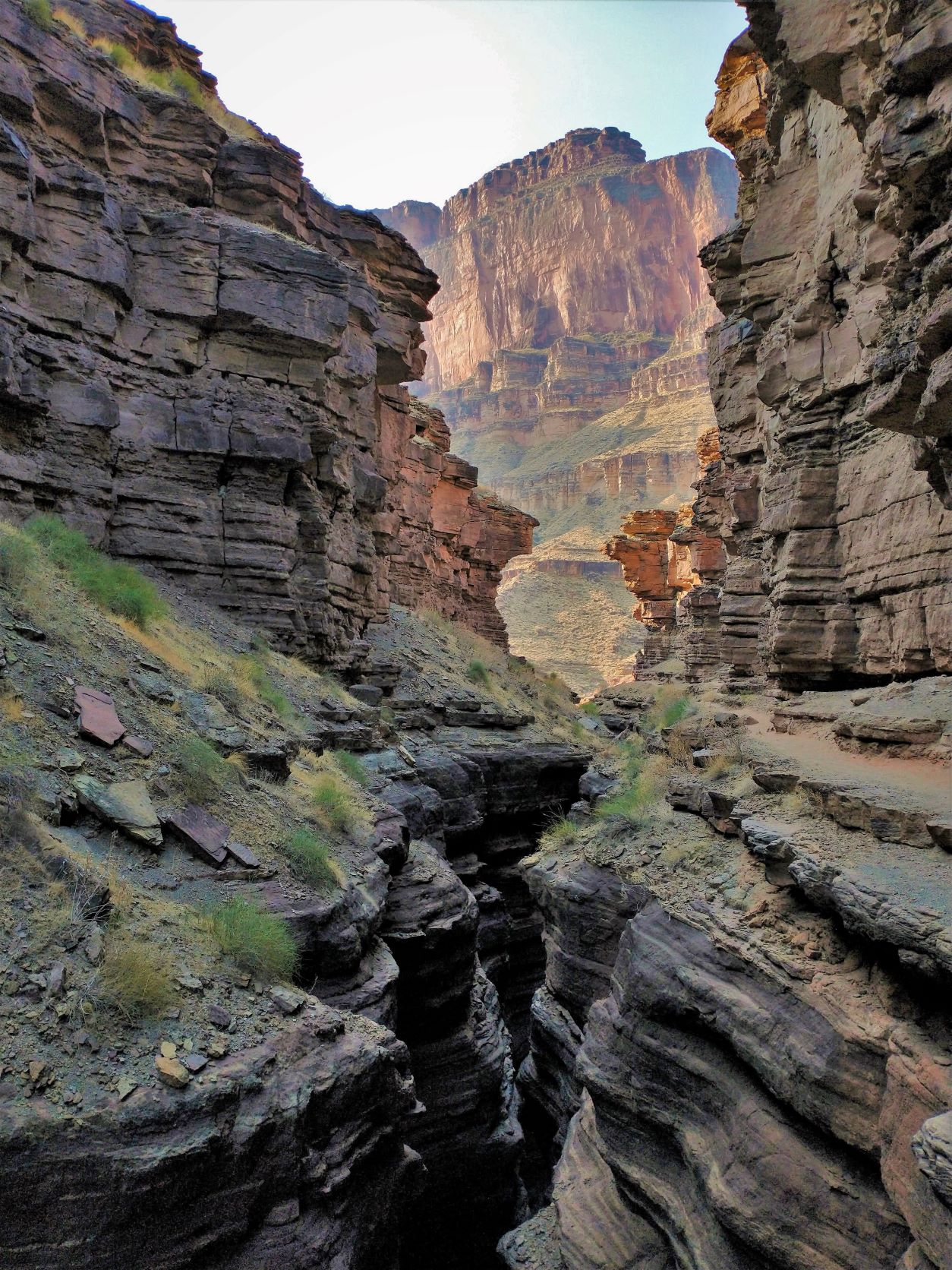 Photo of Deer Creek narrows shows the steep and sheer canyon walls on either side with a narrow slot canyon below