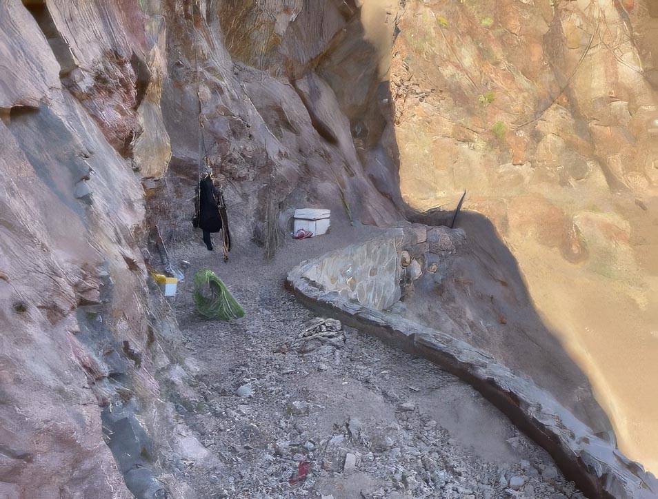 a section of backcountry trail built into a sheer cliff with a masonry wall below the trail surface