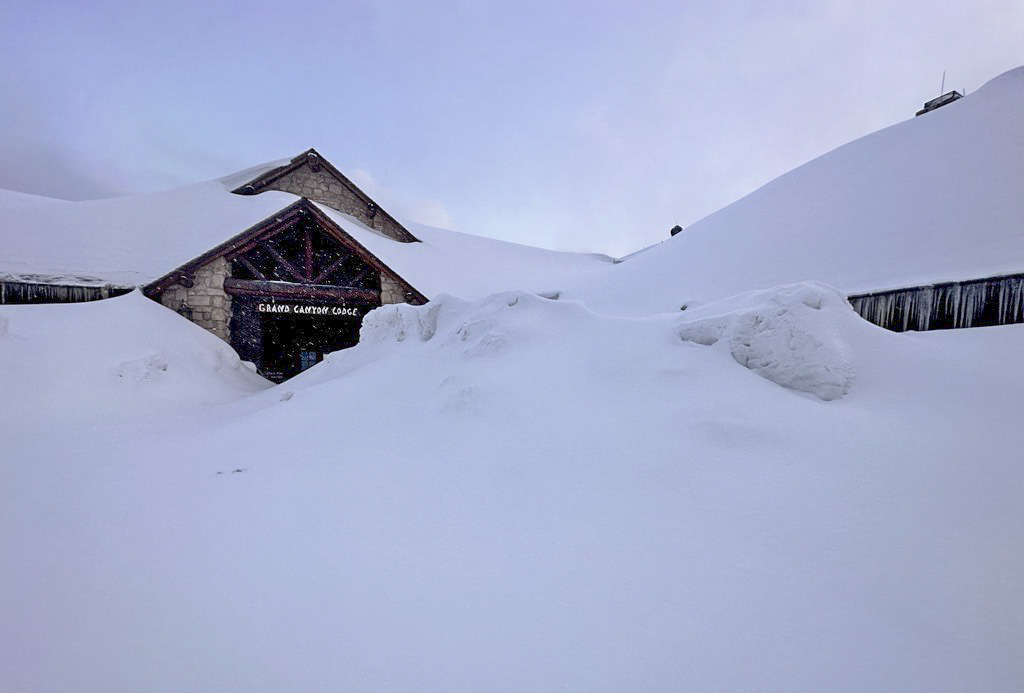 The Grand Canyon Lodge is barely visible under a piling of snowdrifts