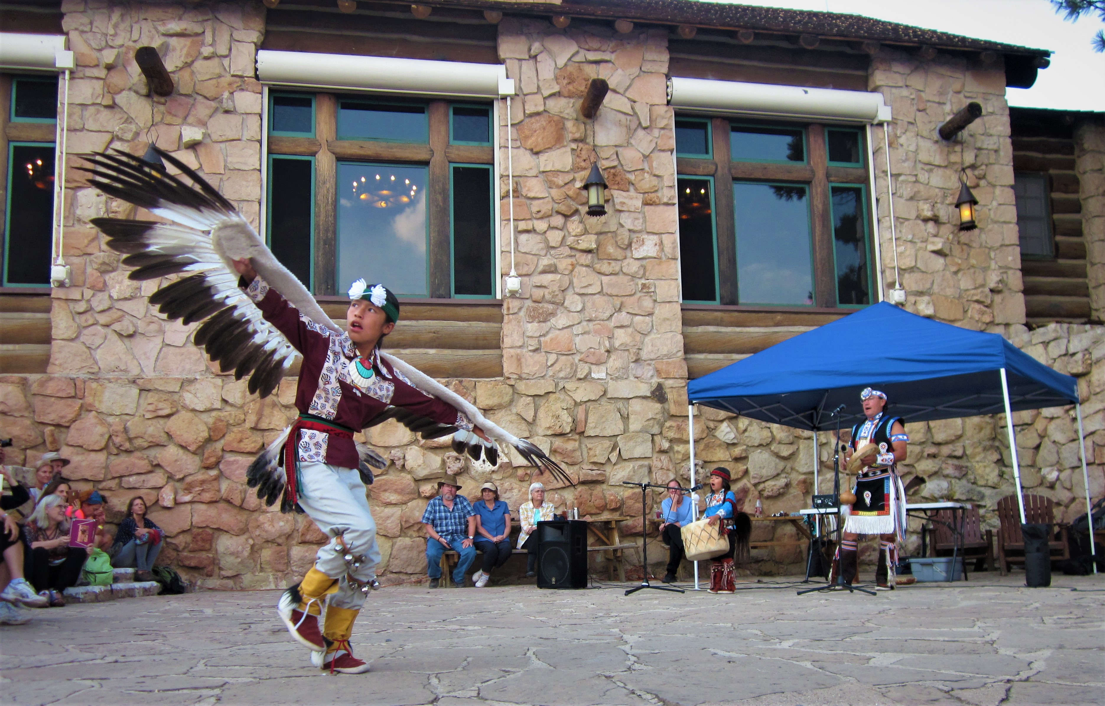 An Indigenous dancer and musicians perform on the North Rim veranda
