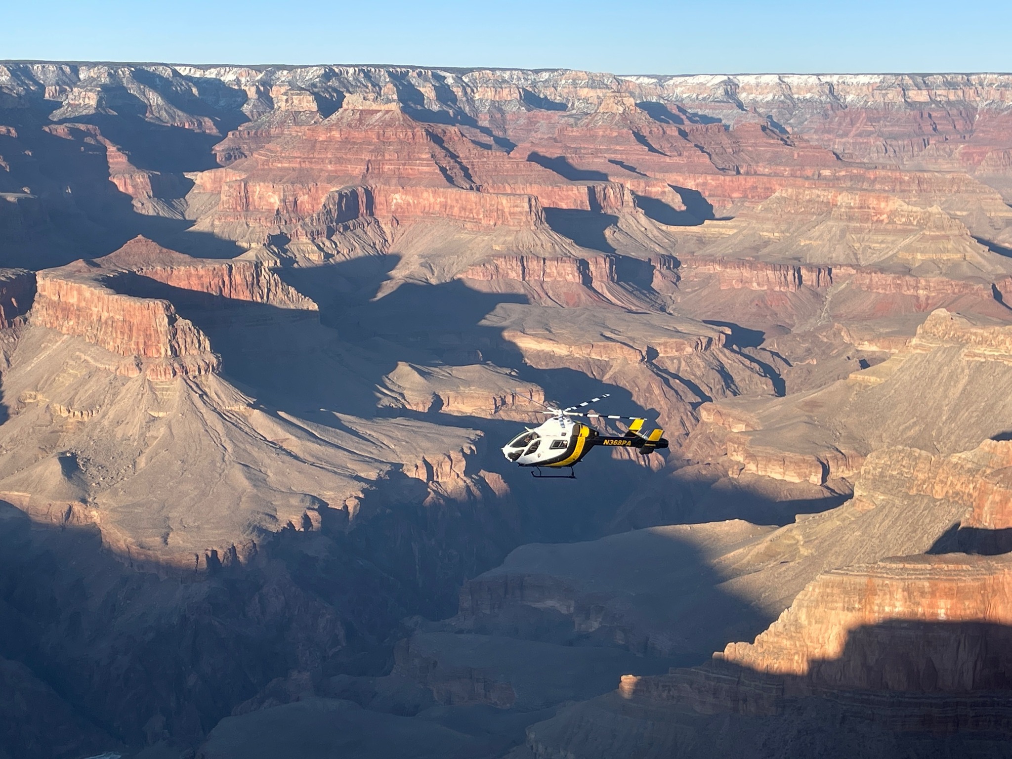 A helicopter hovers over the Grand Canyon