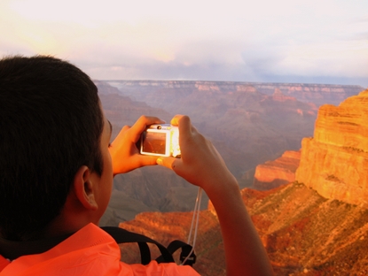 youth photographing sunset at canyon