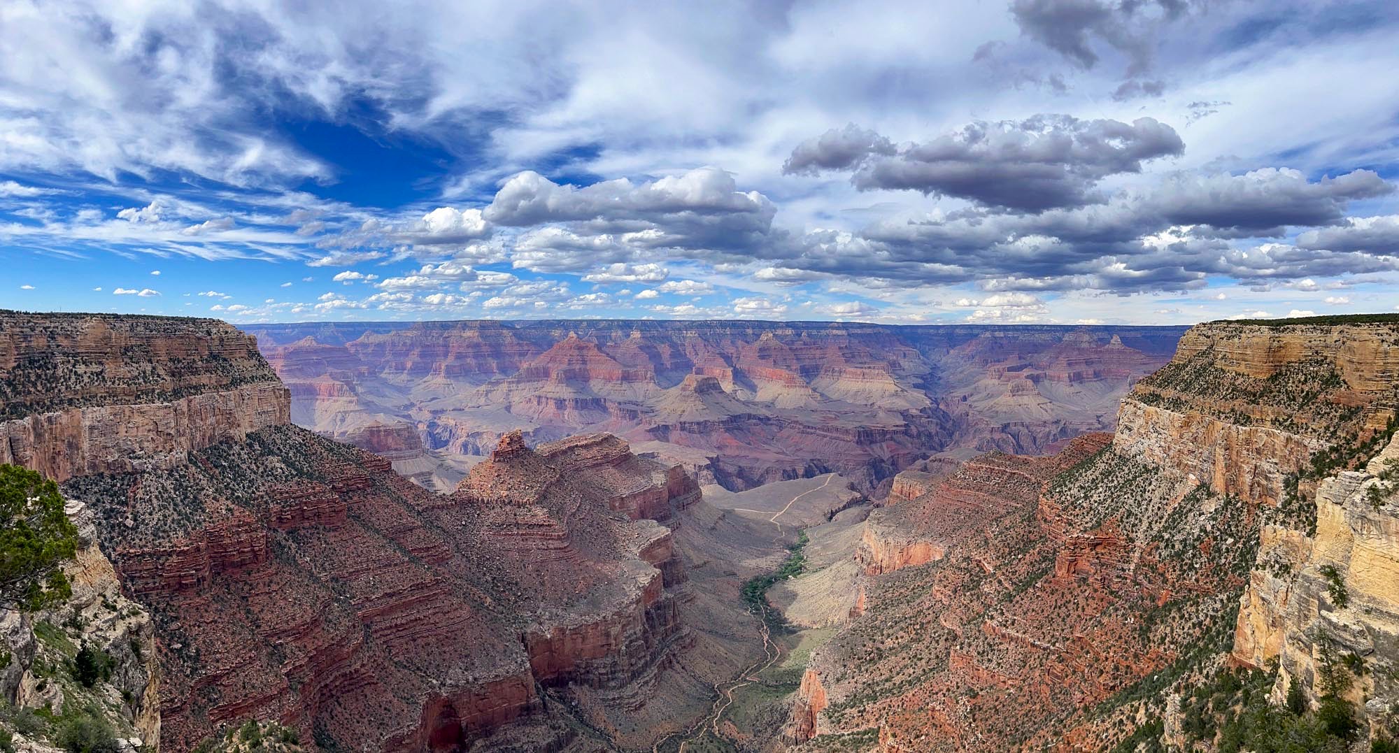 View of a canyon landscape with blue skies and many clouds overhead
