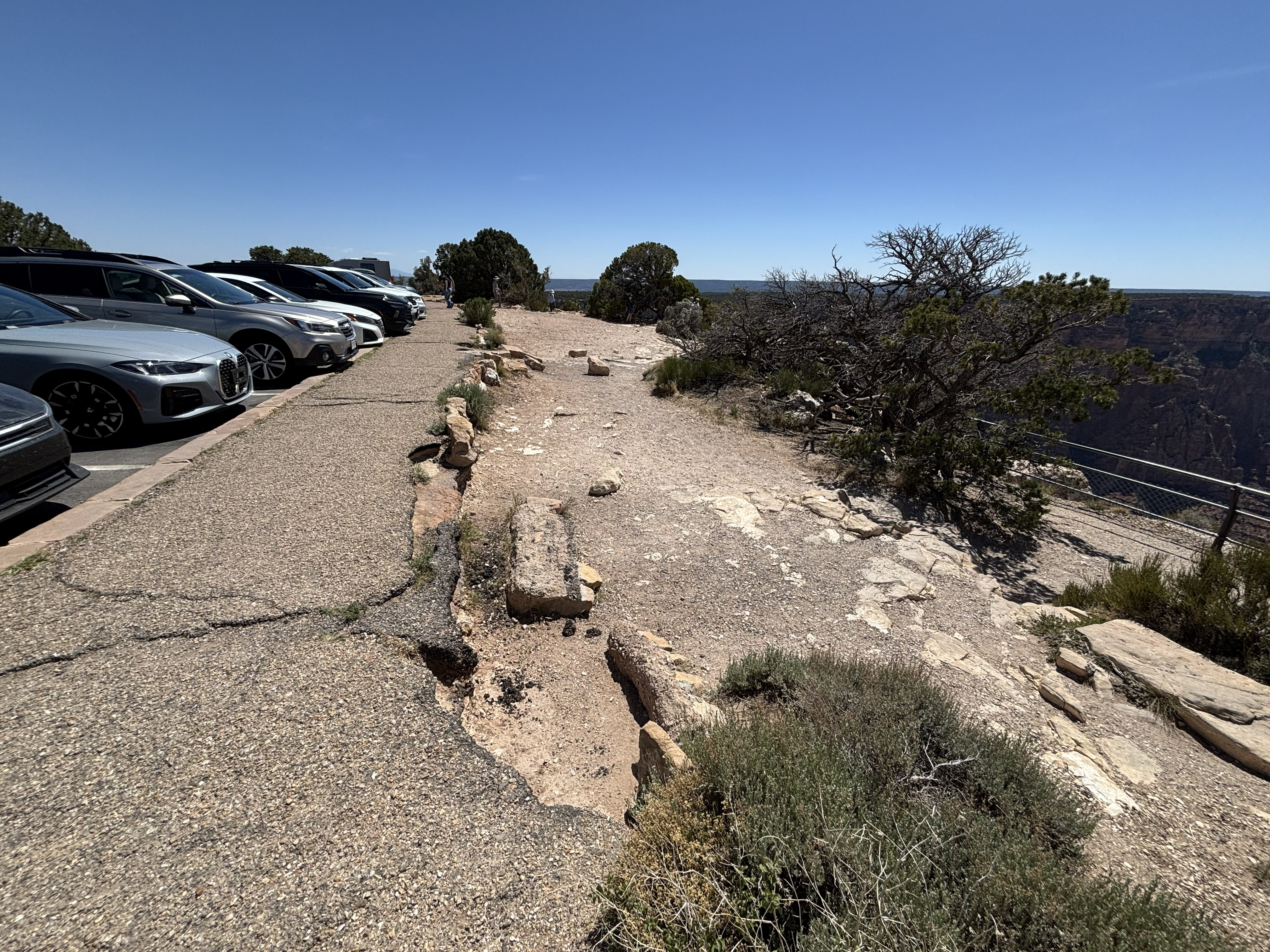 A sidewalk is sloughed off along the rim of the canyon