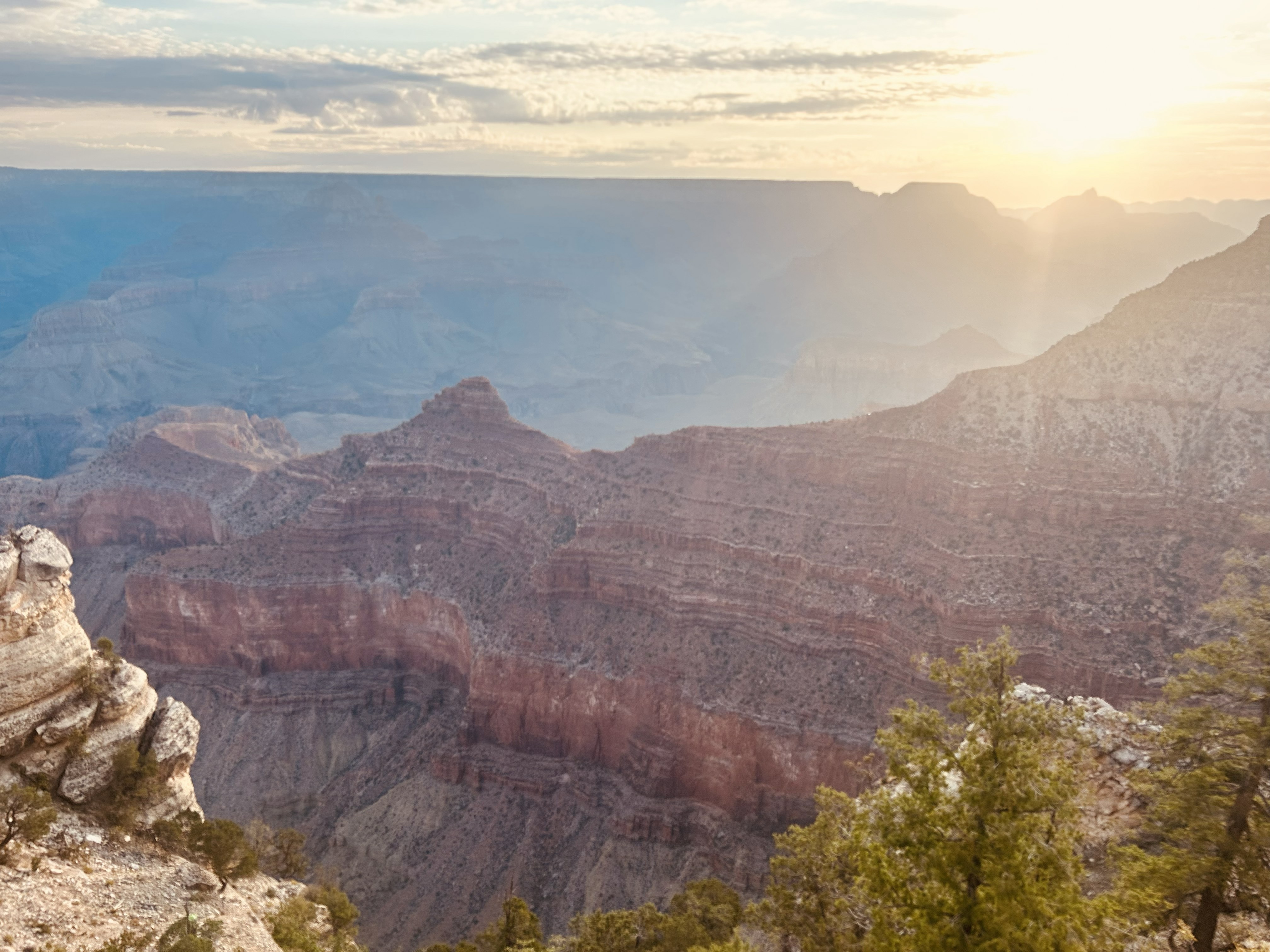 A sunrise over the canyon rim with soft lighting illuminating the canyon