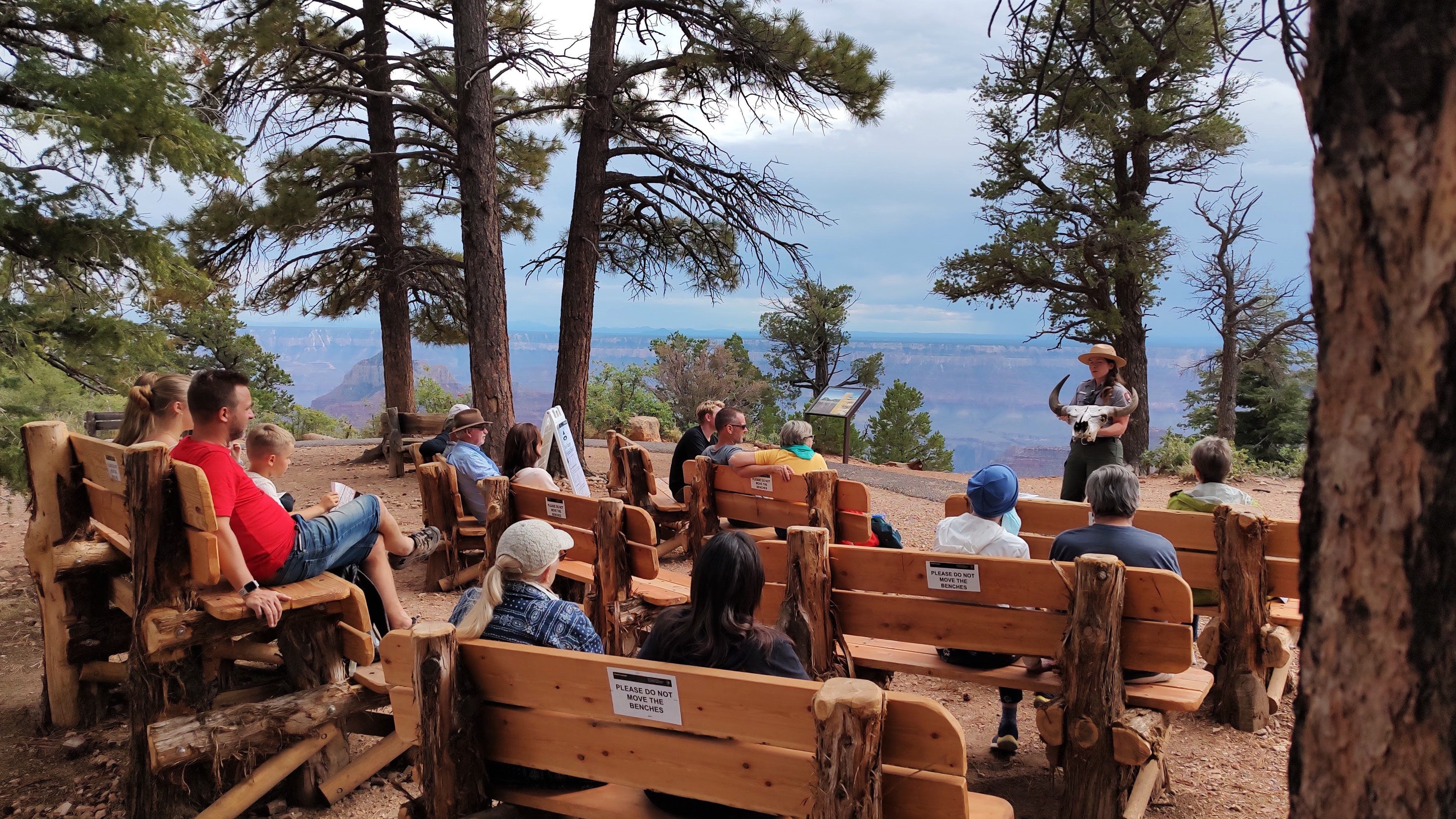 A ranger in a uniform gives a public program to a seated audience