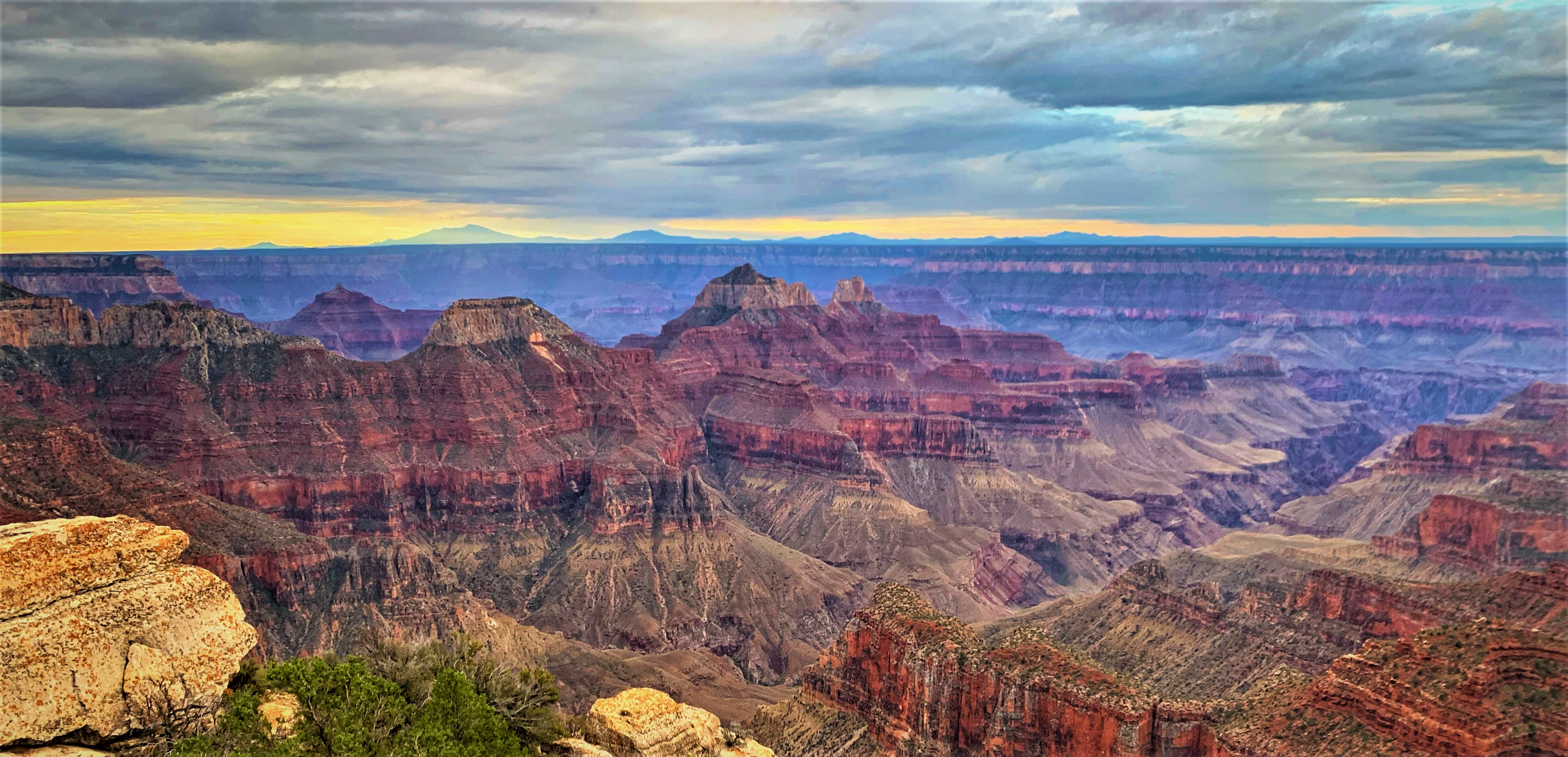 A colorful canyon landscape is seen at sunset from Bright Angel Point on the North Rim