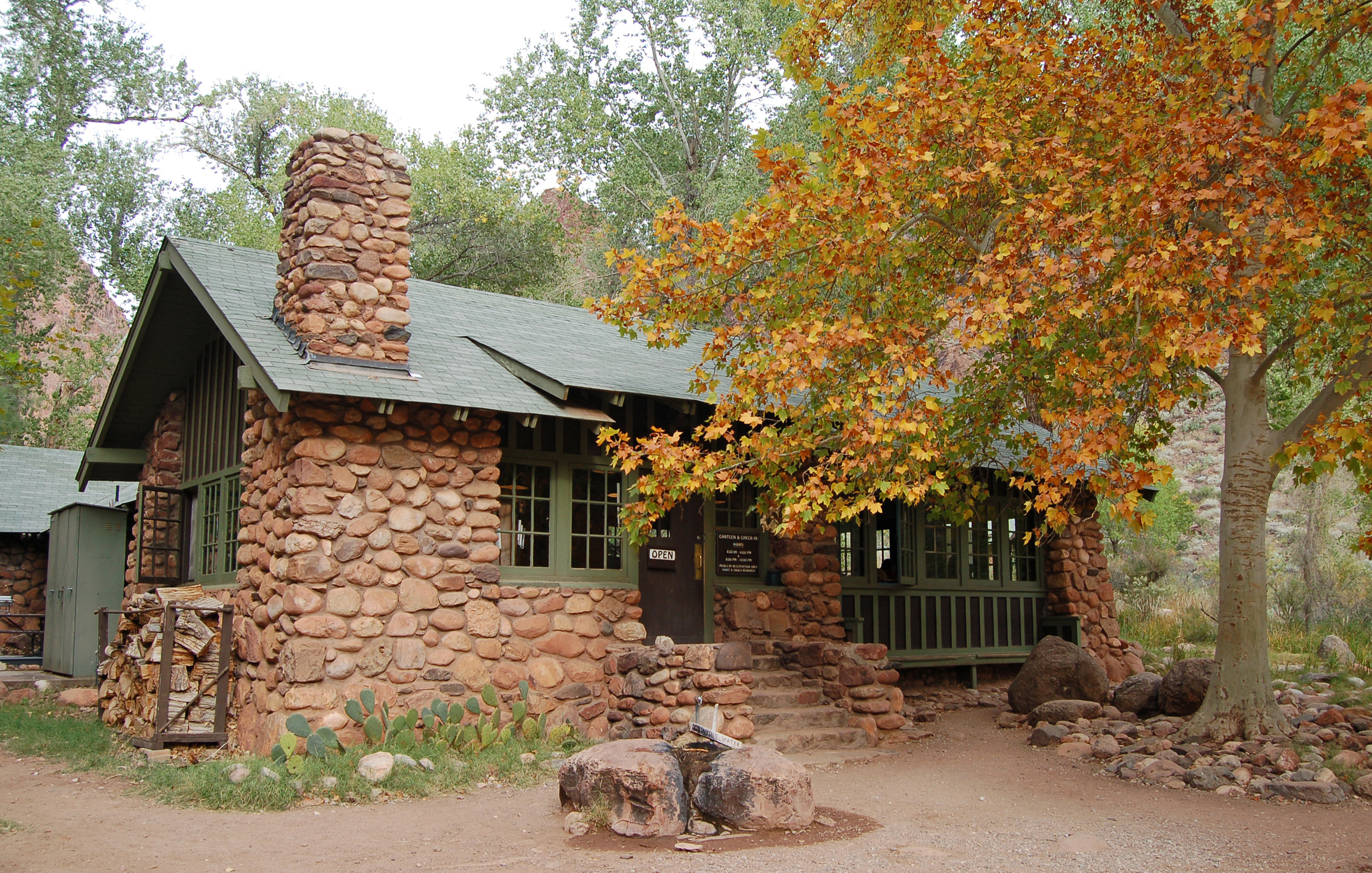 PR Fall Phantom Ranch Lodge stone building next to aspen tree displaying fall leaves.